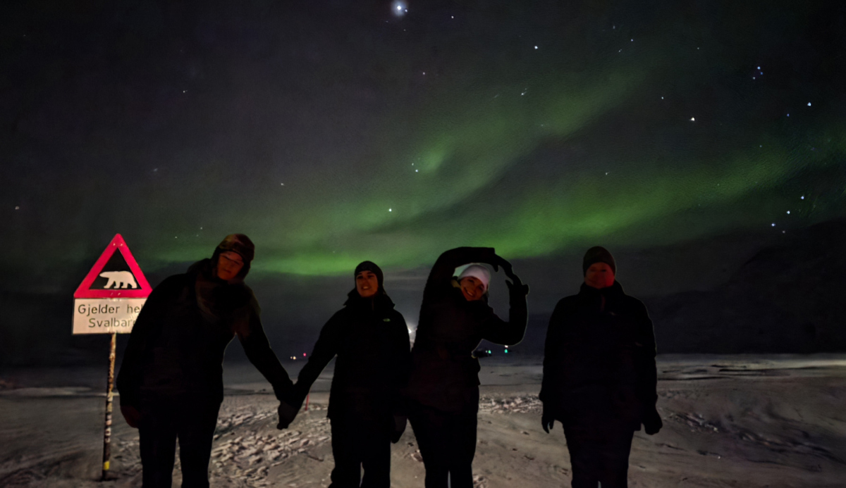 What does it say? The team on land beneath a dancing aurora borealis. (© K. Knittel/Max Planck Institute for Marine Microbiology)